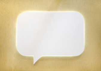 Empty white speech bubble on wooden wall