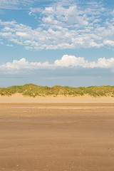 Fototapeta na wymiar Looking back over the sandy beach towards the marram grass covered sand dunes, at Formby in Merseyside