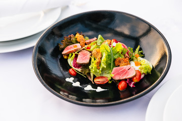 Medium Rare Tuna Salad (Green Coral, Red Coral, Tomato and Salmon Roe) with Touched Sea Urchin in black plate.