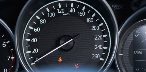 Close up of modern speedometer display in a car dashboard panel .