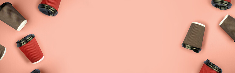 Disposable braun and red cups on orange background. Place for text.