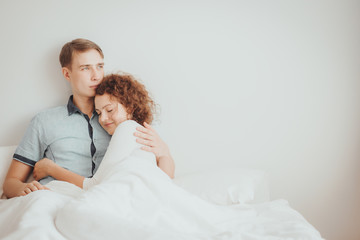 Romantic young couple hugging on the bed