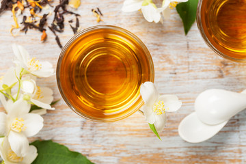 Obraz na płótnie Canvas Glass cup of tea with jasmine flowers