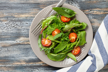 Vegetables salad in a plate on a wooden background.  Top view