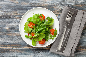 Vegetables salad in a plate on a wooden background.  Top view