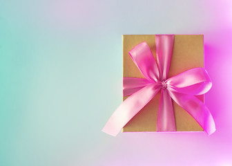 Christmas, birthday, wedding neon card with gift box bow on pink and blue background
