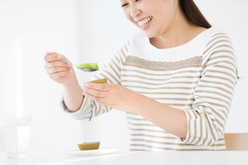 キウイフルーツを食べる女性