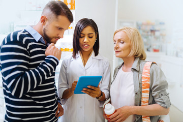 Attentive mature female staring at screen of tablet
