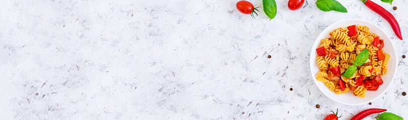 Radiatori pasta with chicken and peppers on white background. Top view. Banner.