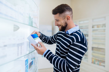 Delighted visitor standing near shelves with medicine