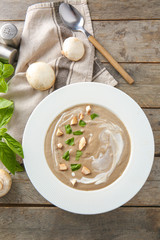 Plate of tasty mushroom cream soup on wooden table