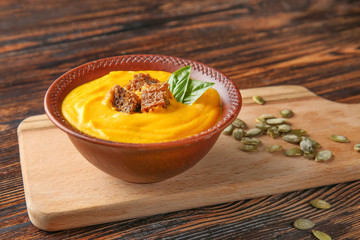 Bowl of tasty cream soup on wooden table