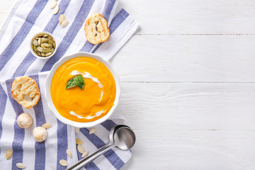 Bowl of tasty cream soup on white table