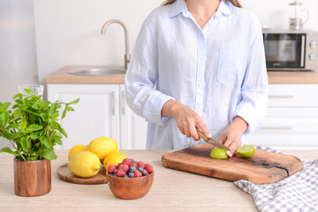 Woman cutting lime in kitchen