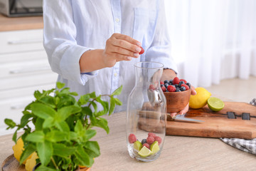 Woman making infused water in kitchen