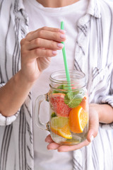 Fototapeta premium Woman with mason jar of infused water, closeup