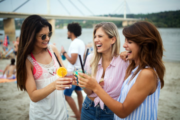 Group of friends hanging out with cocktails at the beach