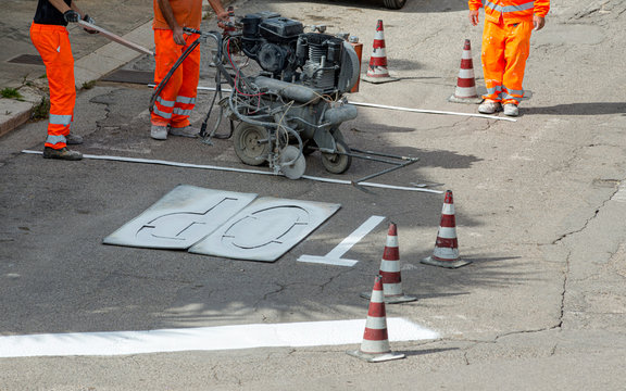 machine and workers at road construction use for road and traffic sign painting