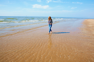 Smiling woman walking on the seaside