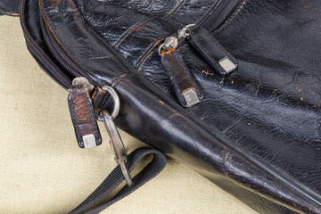 Fragment of old black leather handbag with some bag accessories