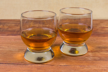 Two portions of brandy in brandy bowls on rustic table