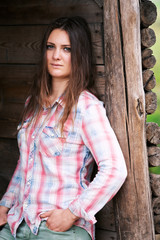 Fototapeta premium brunette young woman standing outdoors at wooden wall