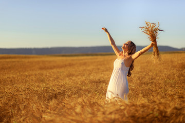 Beautiful young woman in wheat field at sunset outdoor . © Fototocam