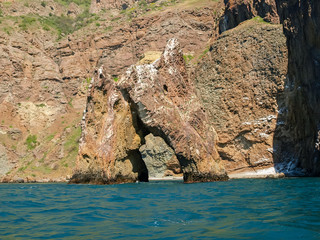 Rock gate of volcanic origin against of the sea shore