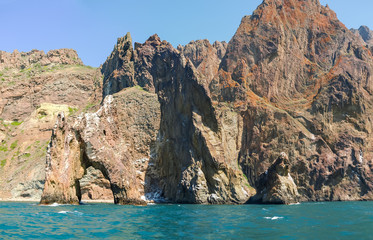 Fototapeta na wymiar Coastal cliffs of volcanic origin on the sea shore