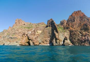 Fototapeta na wymiar Part of coastal cliffs of volcanic origin on sea shore