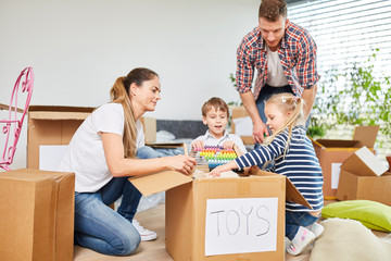 Fototapeta na wymiar Children and parents in teamwork unpacking
