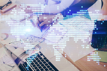 Fototapeta premium International business hologram over hands taking notes background. Concept of success. Multi exposure