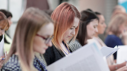 group of business people with documents sitting at the lecture hall.