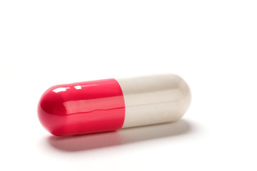 Single capsule pill on white background