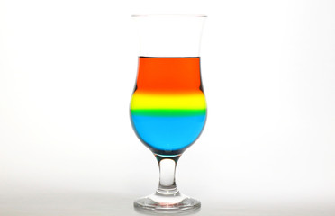 Glass and colored liquids on white background