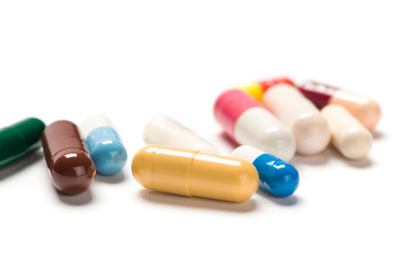 Mix of colorful capsule pills closeup on white background 