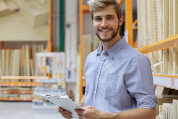 portrait of a smiling young warehouse worker working in a cash and carry wholesale store.
