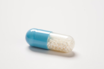 Single capsule pill on white background