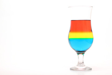 Glass and colored liquids on white background