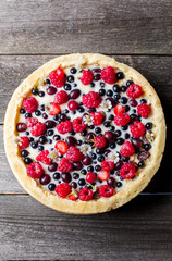 tart with berries on a wooden background