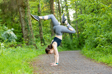 young woman doing a handstand as a fitness workout