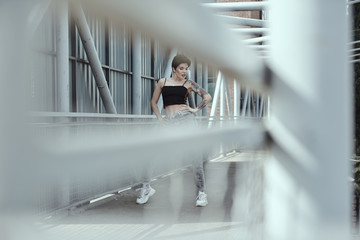 Raven haired young lady with tattoos posing on the bridge