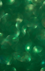 green Lights Festive background with texture. Abstract Christmas twinkled bright bokeh defocused and Falling stars.