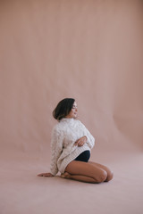 Obraz premium Pregnant woman with long hair in white sweater.