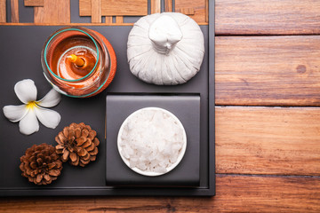 Spa aromatic sea salts, and herbal massage ball on wooden background.