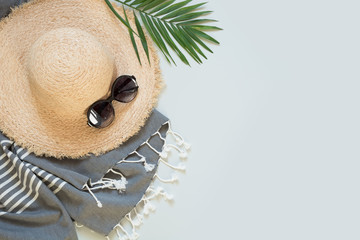 Straw beach sunhat and sun glasses on grey. Female outfit. Summer vacancy concept.