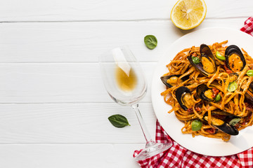 Flat-lay plate of mussels pasta on tablecloth with copyspace