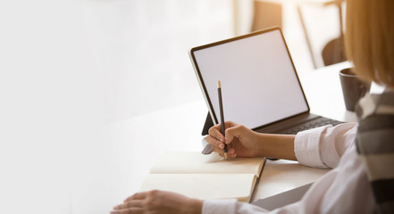 Businesswoman sitting at desk and working with laptop computer.