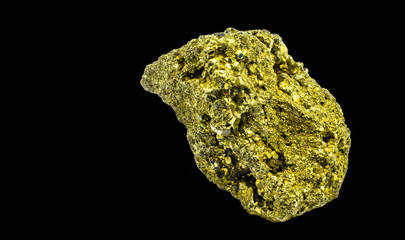lump of shiny cat gold, pyrite, which looks similar to real gold, isolated against a black background
