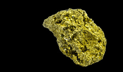 lump of shiny cat gold, pyrite, which looks similar to real gold, isolated against a black...